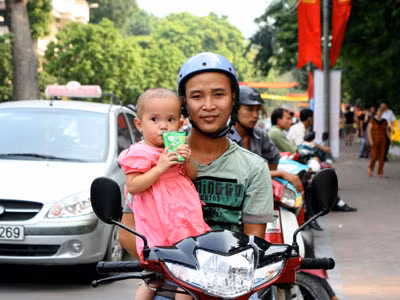 Không tìm được chỗ gửi xe, hai bố con anh Hoàng Văn Bình, Chương Mỹ (Hà Nội) đành ngồi trên xe để ngắm cảnh đường phố