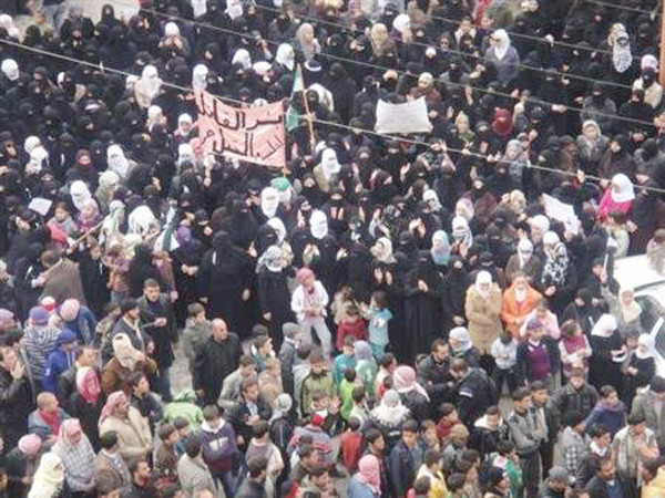 Người biểu tình chống Tổng thống Assad giơ biểu ngữ “Nói với kẻ sát nhân rằng hắn sẽ có số phận giống những người hắn giết” Ảnh: Reuters