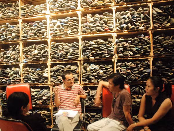 Chiếc kệ khổng lồ với chiếc dép cũ nát trôi dạt được sắp đặt với ý nghĩa biểu tượng của họa sĩ Nguyễn Thị Thanh Mai (Việt Nam) Ảnh: T.N.A