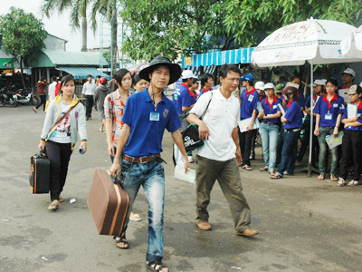 SVTN giúp các thí sinh vận chuyển hành lý tại bến xe Miền Đông ngày 30-6 Ảnh: Quang Phương