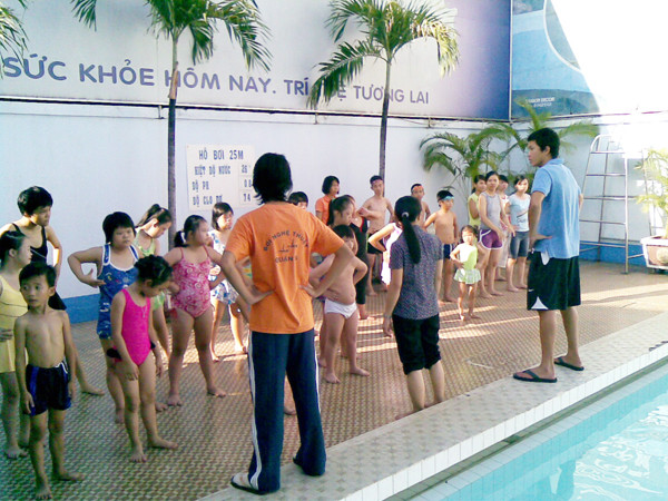 Mỹ Phước (ngòai trái) đang hướng dẫn trẻ khuyết tật trước khi xuống nước