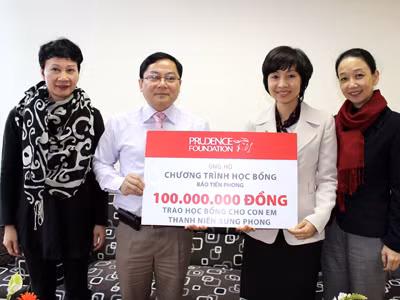 Bà Tina Nguyễn - Phó TGĐ Điều hành Prudential Việt Nam trao tiền ủng hộ quỹ học bổng cho TBT Báo Tiền Phong Lê Xuân Sơn