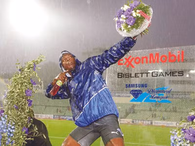 Usain Bolt ăn mừng chiến thắng dưới mưa Ảnh: AP