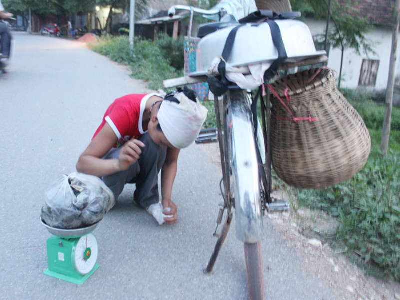 Phụ nữ làng Võ Lao, xã Văn Võ, Chương Mỹ cân ốc bán dọc đường	Ảnh: TV