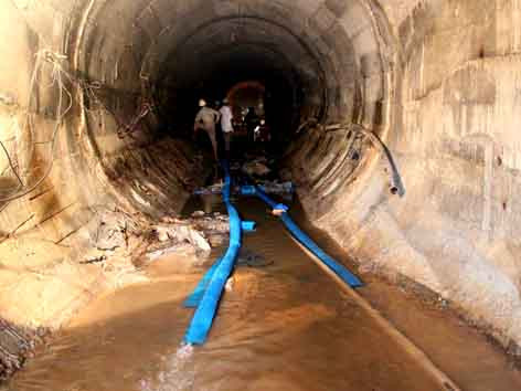 Lực lượng cứu hộ đang khẩn trương bơm nước trong đường hầm ra ngoài. Ảnh: văn tài