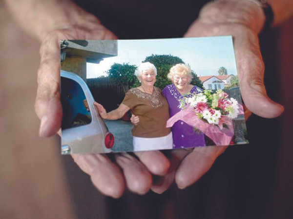 Cụ Disbrow (phải) khoe bức ảnh chụp cùng con gái Betty Jane ngày đoàn tụ. Ảnh: AP