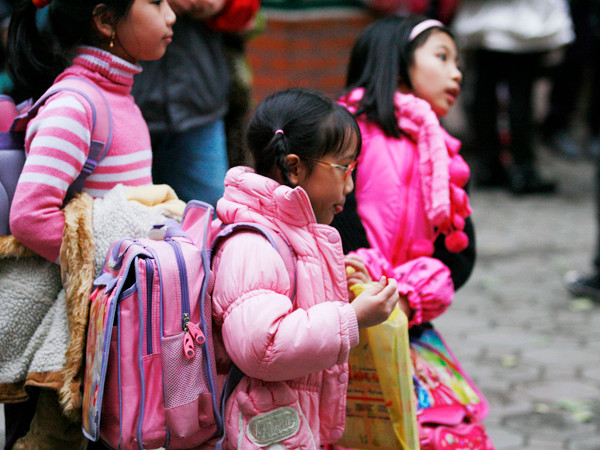 Học sinh tiểu học ở nhiều thành phố lớn phải mang cặp sách nặng. Ảnh: Hồng Vĩnh