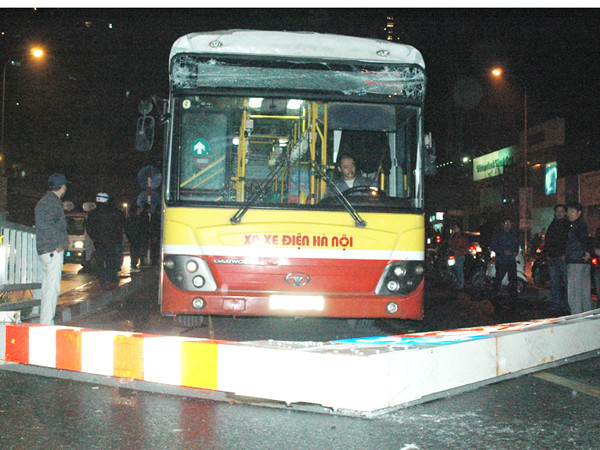 Sau vụ va chạm, thanh giới hạn chiều cao bị đổ chắn hết đường đi, kính đầu xe bị hư hỏng