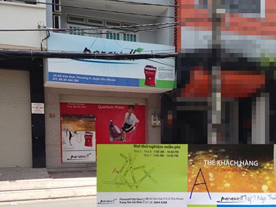 Cánh cửa căn nhà số 25 đóng kín bằng tấm pa nô quảng cáo thật to các sản phẩm của Công ty Parawell (ảnh lớn) và tấm thẻ thành viên khách hàng mà nhân viên Công ty Parawell cấp cho phóng viên (ảnh nhỏ) Bệnh nan y: Dùng máy là khỏi (!?)