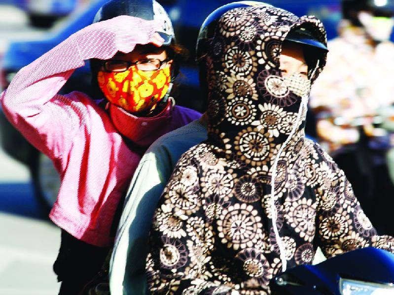 Nhiều người Hà Nội mặc kín mít khi ra đường để chống nóng	Ảnh: Hồng Vĩnh