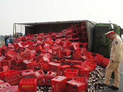 Xe chở bia bị lật, dân giúp tài xế thu gom