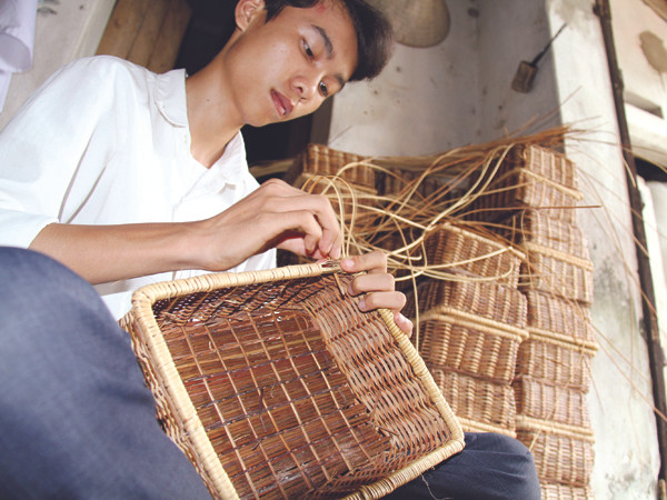 Lê Đức Duẩn, tân thủ khoa ĐH Dược tranh thủ giúp mẹ đan đồ mây tre Ảnh: Trường Phong