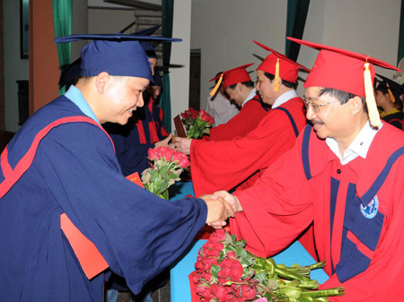 Phó TBT Báo Tiền Phong Vũ Tiến và lãnh đạo Viện ĐH Mở trao bằng cử nhân và hoa cho các học viên tốt nghiệp. Ảnh: Tuấn Nguyễn