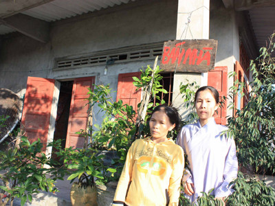 Vợ con ông Thành trước ngôi nhà nơi xảy ra vụ án