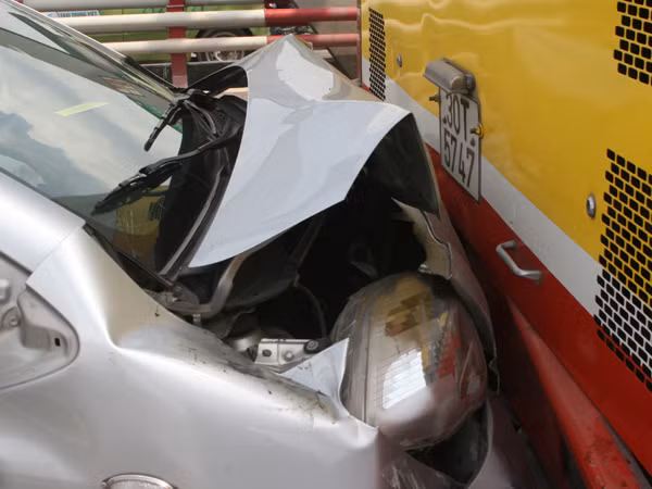 Đầu chiếc ô tô hiệu Toyota YarisDính chặt vào đuối xe buýt