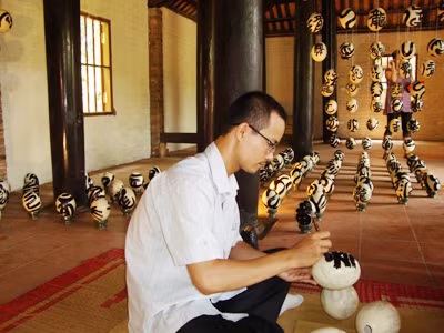 Thư pháp gia Trần Trọng Dương trình diễn thư pháp trên trứng Ảnh. T.Toan