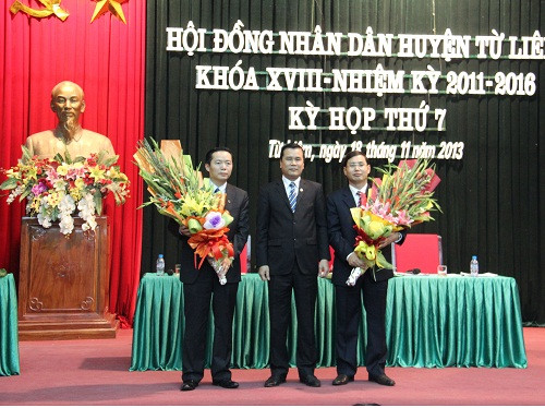 Bí thư Huyện ủy Từ Liêm Lê Văn Thư tặng hoa chúc mừng tân Chủ tịch huyện Nguyễn Văn Tứ (bên phải) và Phó Chủ tịch huyện Trần Thanh Long