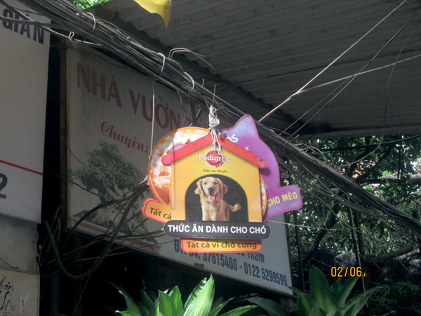 Tấm biển quảng cáo được treo lủng lẳng trên dây điện