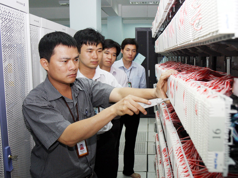 Tào Đức Thắng (trái) hướng dẫn thao tác đầu nối luồng E1 tại Tổng trạm Pháo đài Láng (Hà Nội)