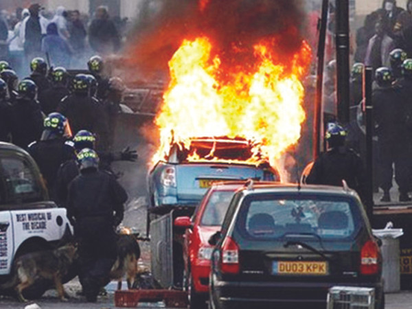 Cảnh sát chống bạo động đối phó tình trạng đốt xe ở London. Ảnh: BBC