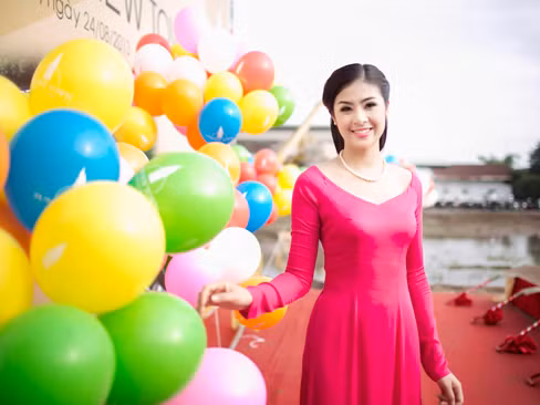 Ngọc Hân mặc áo dài hồng rực đi làm từ thiện