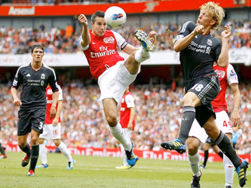 Robin van Persie (giữa) trước sự truy cản của Dirk Kuyt (Liverpool) ở lượt đi.