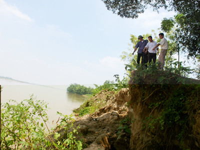 Hơn 1km đê quai đã hòa vào dòng nước, trơ lại những mỏm đất cao gần 10m Ảnh: T.V