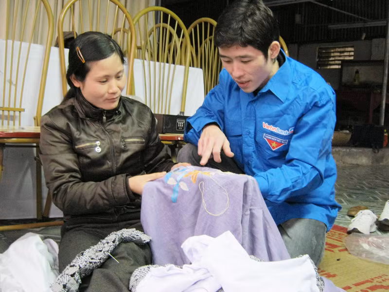 Nguyễn Thế Quyết (phải) dạy nghề cho bạn trẻ. Ảnh: Doãn Mẫn