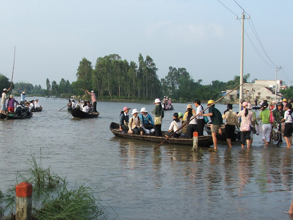 Đi lại, sơ tán người, của cải trong xóm bằng thuyền. Ảnh: Nam Cường