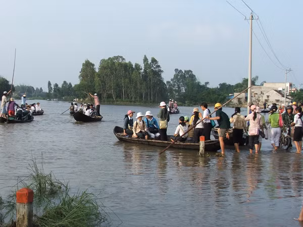 Đi lại, sơ tán người, của cải trong xóm bằng thuyền. Ảnh: Nam Cường