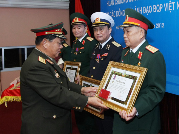 Bộ trưởng Quốc phòng Lào (trái) trao Huân chương cao quý Itsala của nhà nước Lào cho tướng lĩnh cấp cao trong Quân đội Việt Nam, ngày 21-7