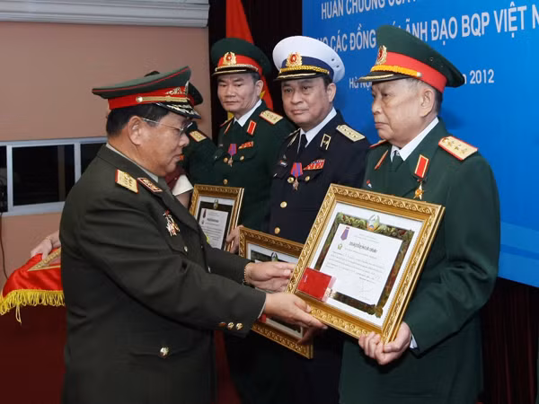 Bộ trưởng Quốc phòng Lào (trái) trao Huân chương cao quý Itsala của nhà nước Lào cho tướng lĩnh cấp cao trong Quân đội Việt Nam, ngày 21-7