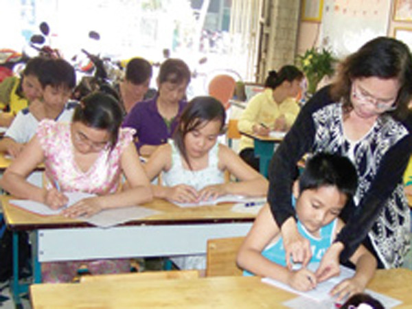 Cô Uyên đang hướng dẫn cho học viên tập viết chữ đẹp. Ảnh: H.Phương (Thanh Niên)