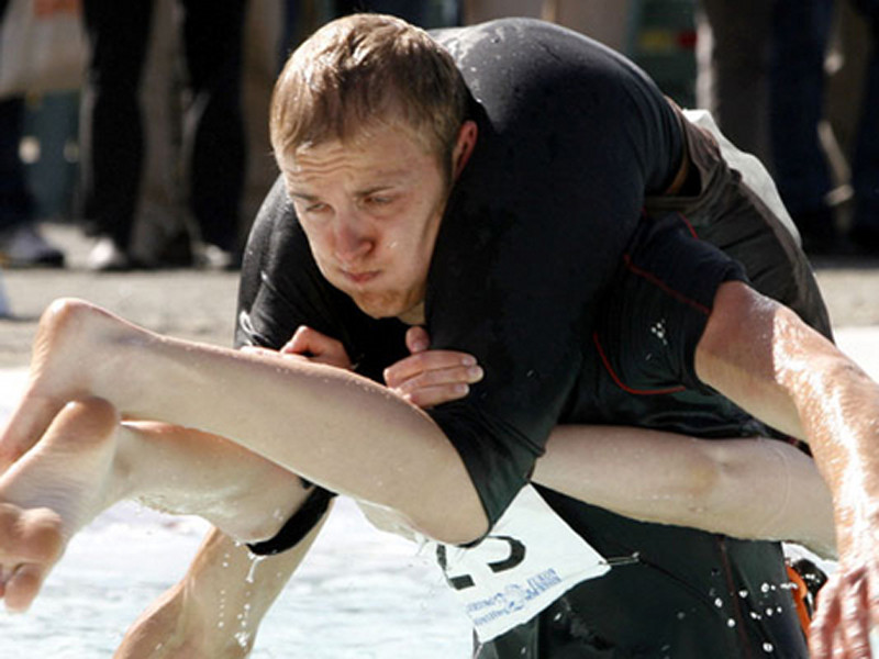 Anh Taisto Miettinen đang cõng vợ Kristiina Haapanen trên đường đua