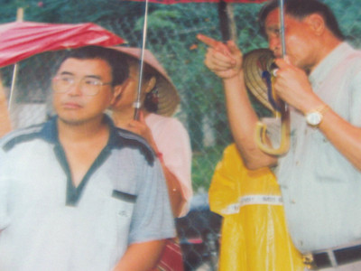 Ông Bùi Văn Sướng (cầm ô bìa phải) theo dõi quá trình tìm hài cốt