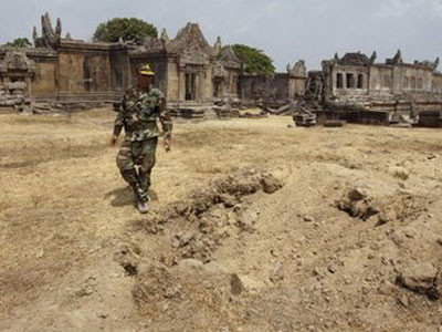 Lính Campuchia đứng cạnh hố đạn pháo Thái Lan cạnh đền Preah Vihear