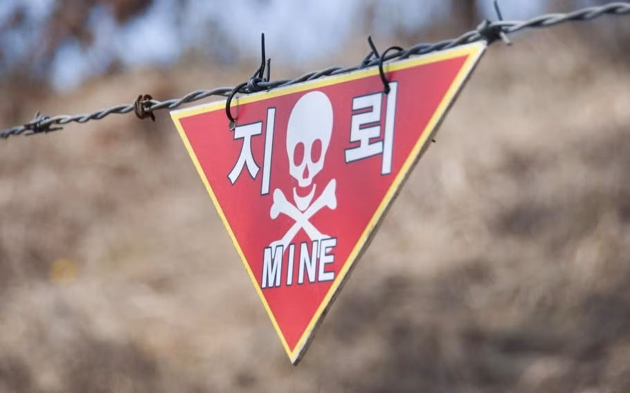 a-land-mine-warning-hangs-from-barbed-wire-at-the.jpg