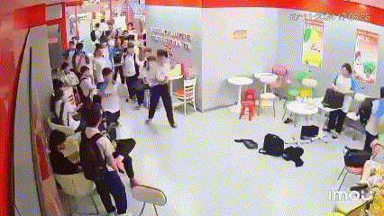 Thiếu niên cầm gậy đánh vào đầu thiếu niên áo đen.