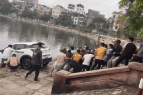 Hàng chục người đàn ông cùng nhau kéo xe lên bờ (Ảnh cắt từ clip).