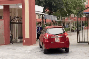 Hai học sinh đứng ở cổng trường, cúi đầu chào mỗi khi có giáo viên vào trường (Ảnh: Cắt từ clip mạng xã hội).