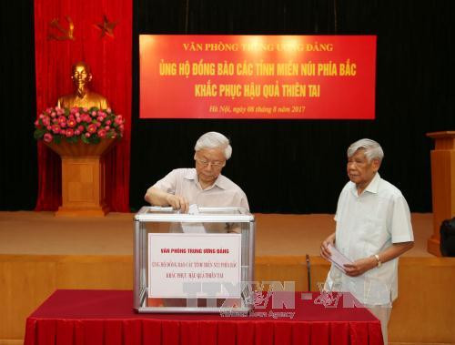 Tổng Bí thư quyên góp ủng hộ người dân vùng mưa lũ (Ảnh TTX) 
