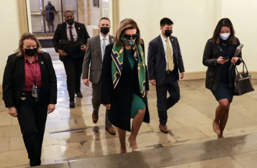 Chủ tịch Hạ viện Mỹ Nancy Pelosi ( giữa) và các hạ nghị sỹ bước vào bỏ phiếu thông qua gói cứu trợ COVID-19.