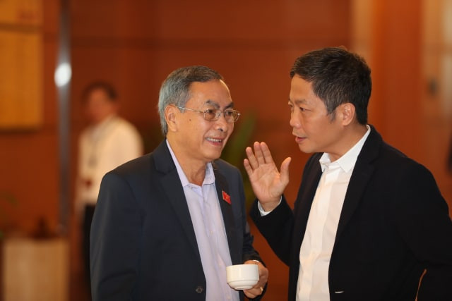 Các đại biểu trao đổi bên hành lang Quốc hội. Ảnh Như Ý