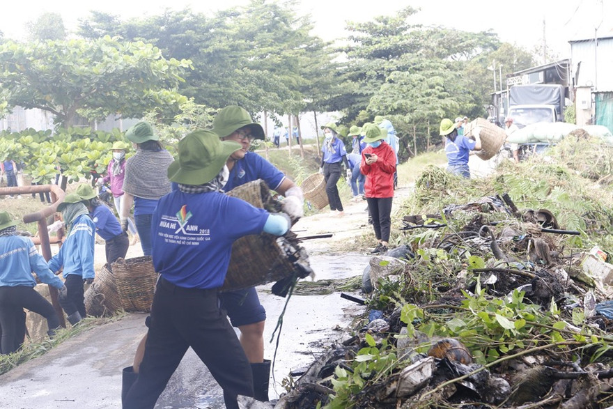 Các tình nguyện viên dọn rác, phát quang bụi rậm bên dòng kênh. 