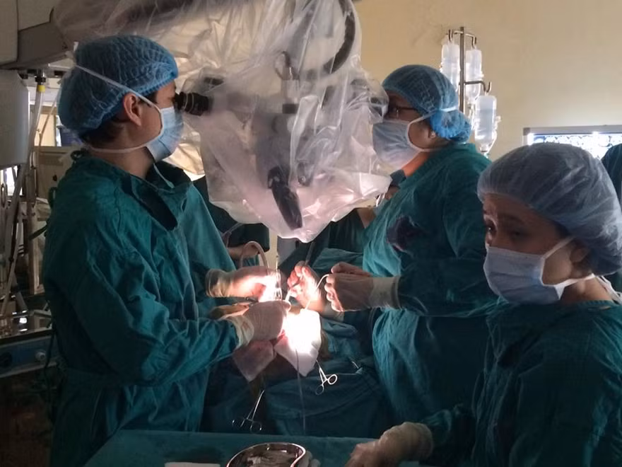 Các thầy thuốc Khoa Ngoại Thần kinh- Bệnh viện K đang thực hiện ca phẫu thuật "bóc" khối u não cho bé Q. Ảnh BSCC