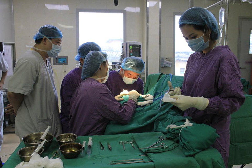 Các BS đang phẫu thuật tạo hình lại vành tai cho bệnh nhân. Ảnh: BV E cung cấp