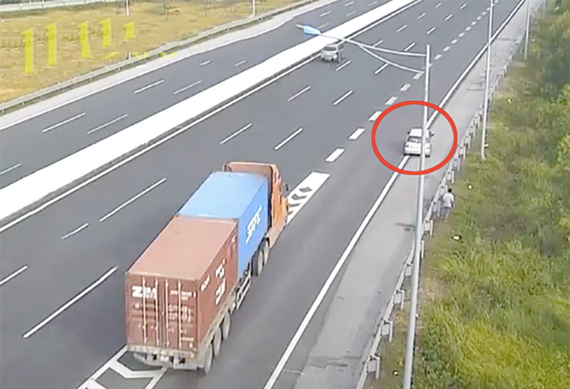 Chiếc xe con (bên phải) lùi trên làn khẩn cấp của cao tốc Hà Nội - Hải Phòng, khiến chiếc xe container phía sau phải đánh lái khẩn cấp. Ảnh chụp từ clip.