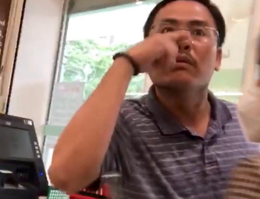 Người kéo khẩu trang xuống thách thức bảo vệ chụp hình lại.