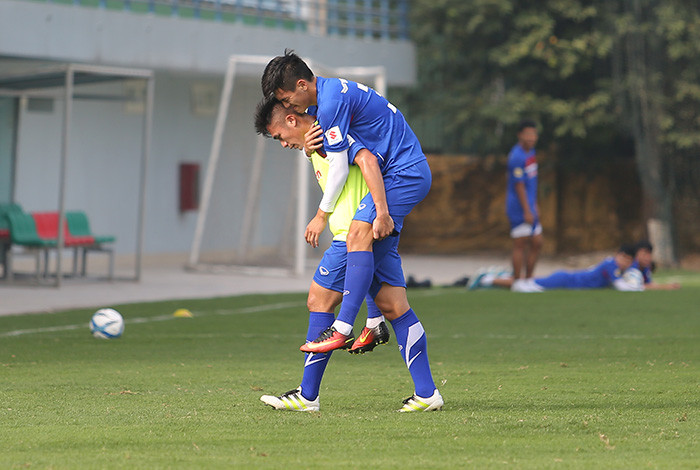 Đồng đội dìu Tiến Linh khỏi sân tập.