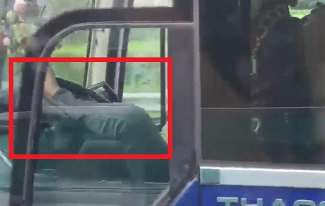 Tài xế xe khách dùng chân điều khiển xe đã bị người đi đường ghi lại clip. Ảnh cắt từ clip.